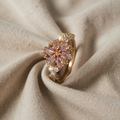 Rosa og gullglitrende ring med blomsterdesign